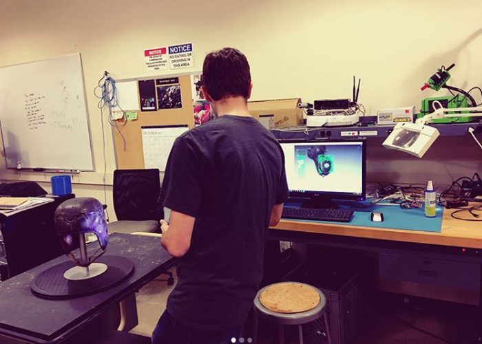Student using Artec 3D scanner in engineering lab to scan football helmet from Georgia Tech Archives