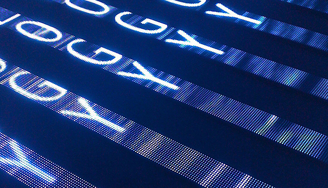 Letters O, G, and Y repeat in stylized rows, cutting diagonally across the frame in blue light. Photograph by Jeff Stvan from FOR[A] Photography and is provided under a Creative Commons NCBYND license.