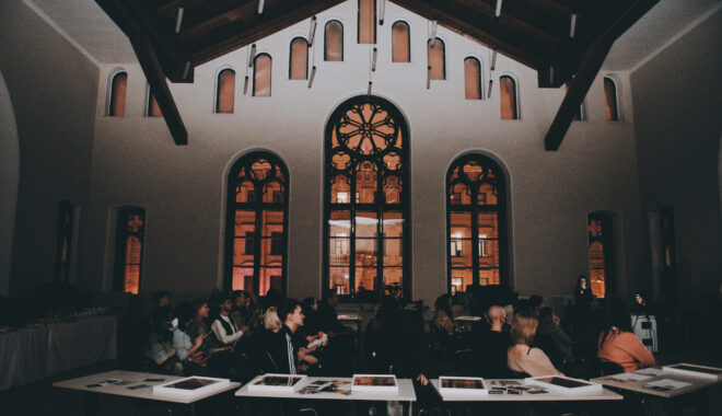 Conference attendees are pictured from the side, under dramatic Russian Orthodox church windows.