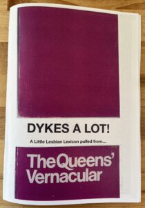 White and magenta book saying "Dykes A Lot...Queen’s Vernacular"