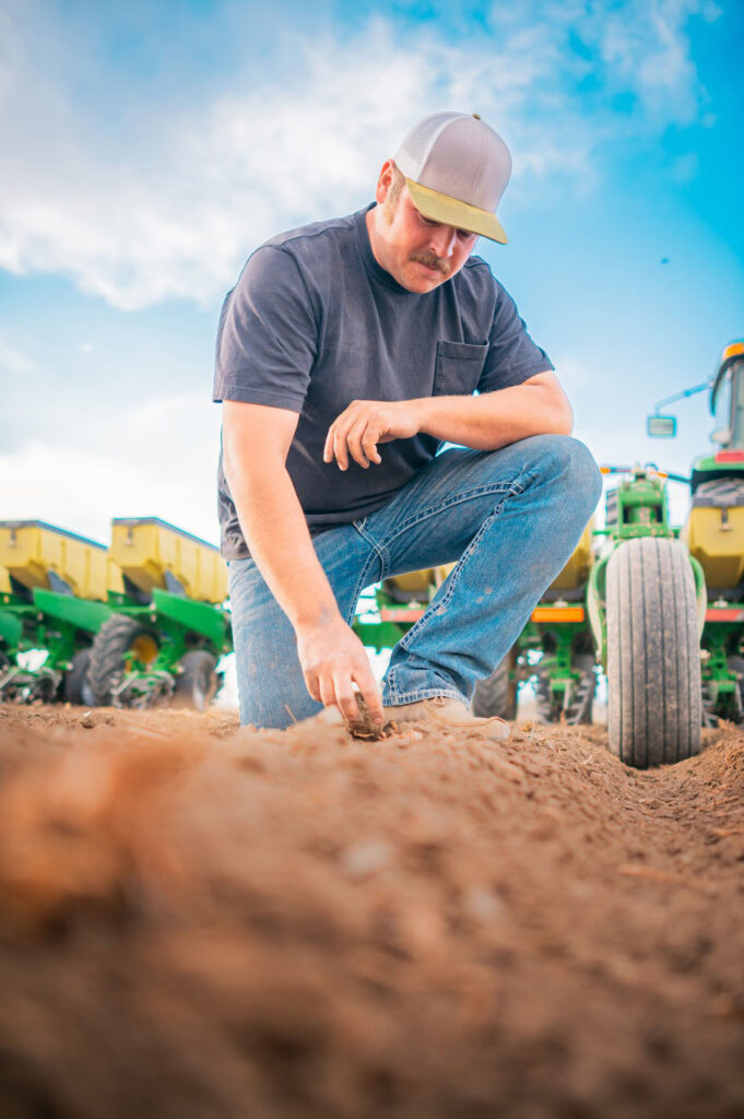 Farmer Checks Seed Depth Behind Planter
