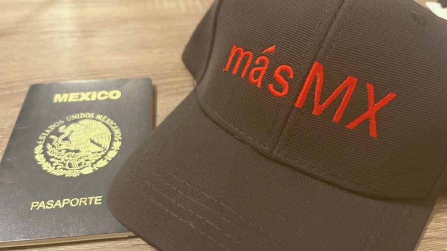 A Mexican passport next to a hat with the másMexico (másMX) logo.