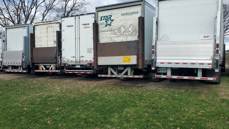 A lineup of lift-gate trailers, either rented or owned.