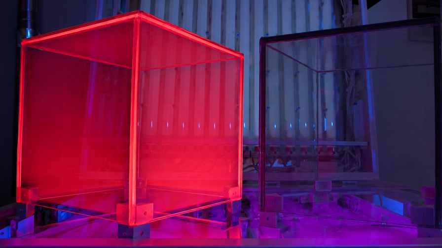 A demonstration shows glass with a spectral-shifting coating that converts UV light into red light.