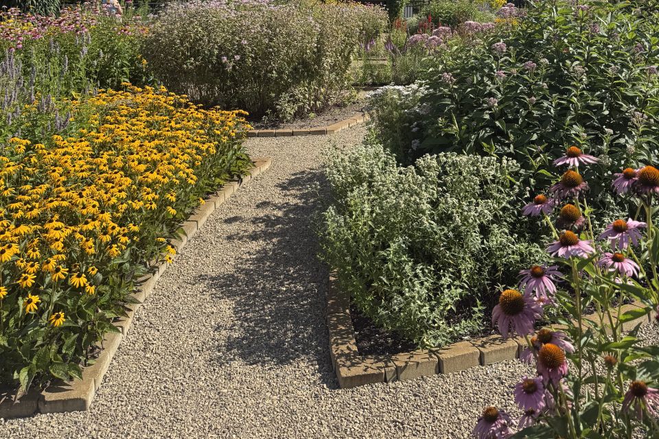 Gravel paths and brick edging define the individual planting areas within the Circle Garden’s geometric layout.