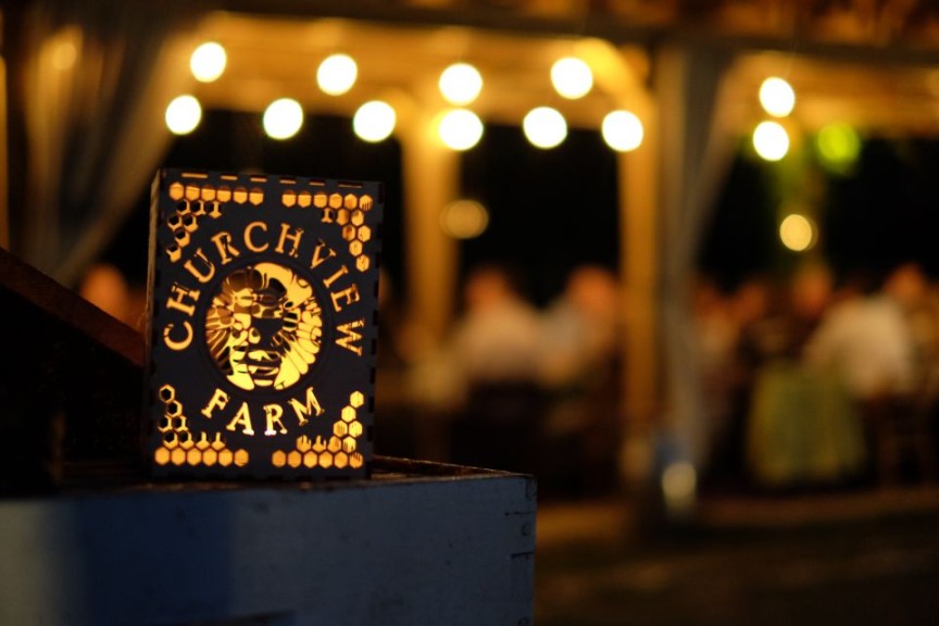 Churchview Farm luminaria with a farm dinner in progress in the background