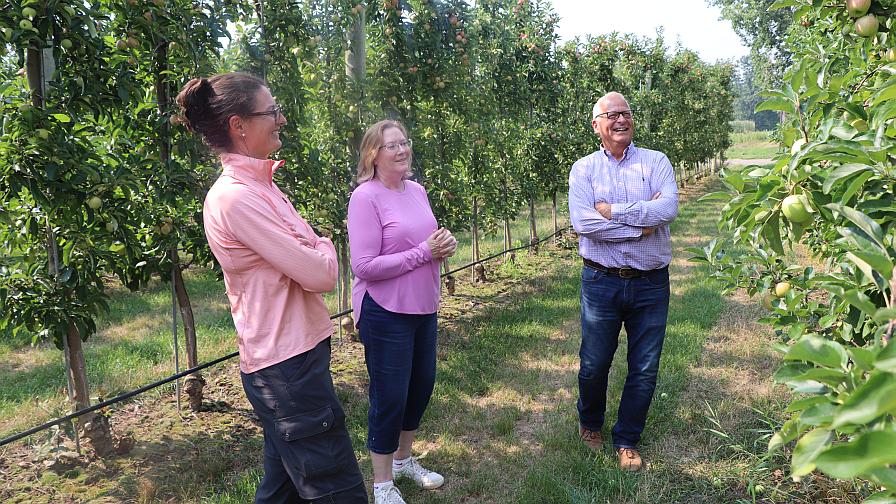 Jim Engelsma with colleagues in the apple orchard