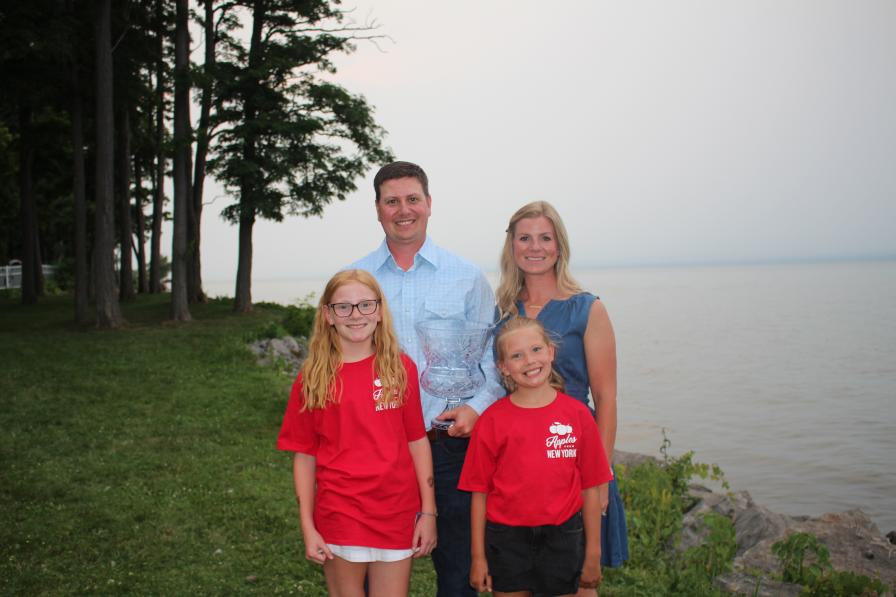 2026 Apple Grower of the Year Bobby Brown accepts trophy with his family around him
