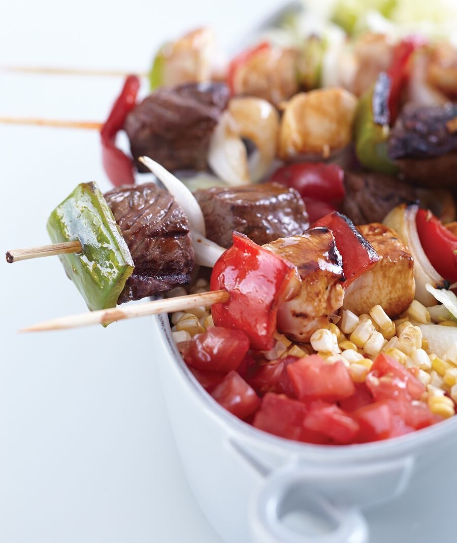 Skewers of marinated chicken, steak, and vegetables are easy for guests to handle at a casual al fresco dinner.