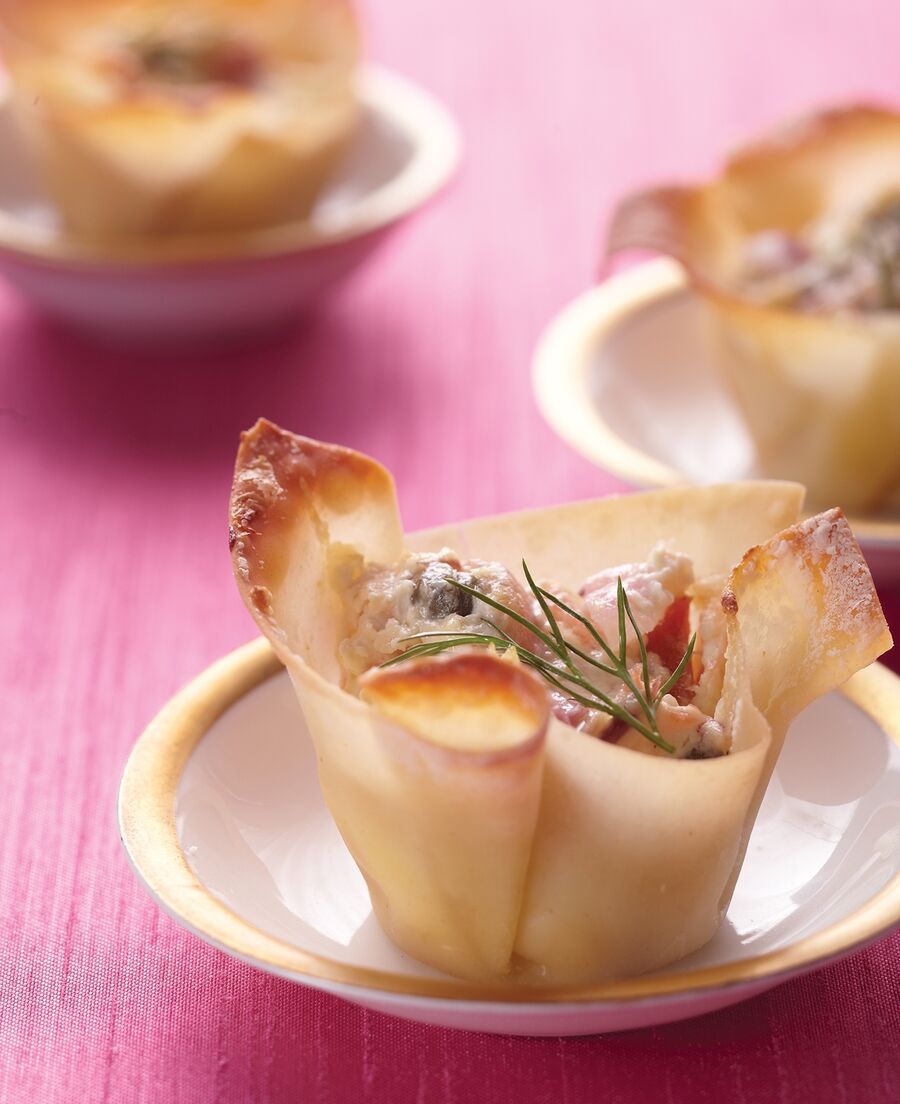 Baked wonton cups cradle bite-sized tastes of savory smoked salmon. Display these beauties on trays set out for guests to help themselves or on pretty individual dishes.