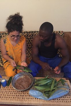 A Puerto Rican woman and Cameroonian man sit on a couch, cooking together