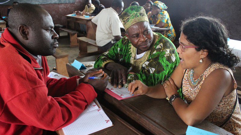 A Puerto Rican woman and three Cameroonian professionals sit together at a table, working.