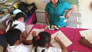 One teacher watching three students write