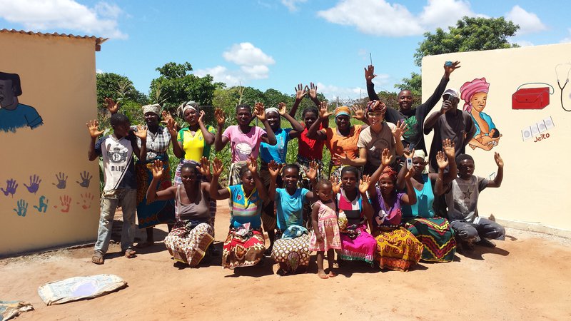 Blonde White American celebrates with Mozambican friends, colleagues and community members.