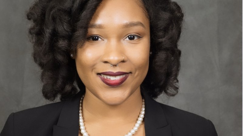 A young Black woman smiles in a professional headshot