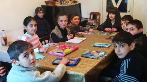 Students sit around a table.