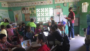 Several kids sitting down in a classroom