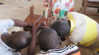Three students looking at experiment being conducted on a chair