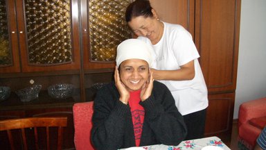 Mahima's host mom ties a customary scarf on her mom during her family's visit in Kyrgyzstan.