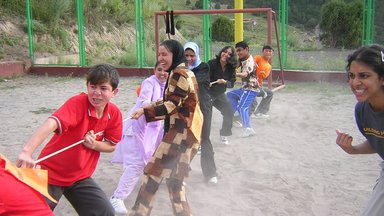 Several kids playing pulling a rope