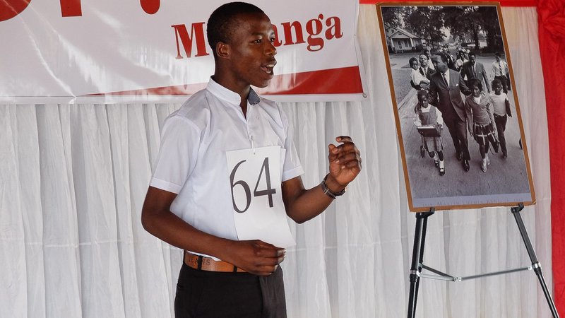 A student delivers a speech from the front stage