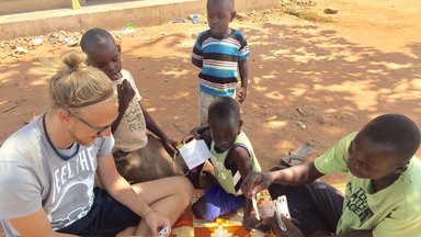 A Peace Corps Volunteer plays with children in Uganda.