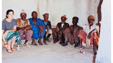 A female Volunteer in Mali stand with community elders.