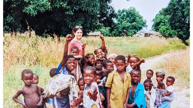 A female Volunteer in Mali plays with local children.