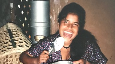 A young Nepali woman cooking in her home.