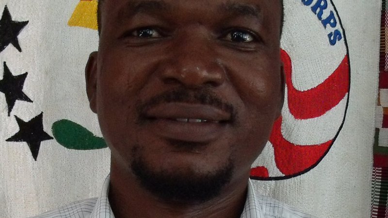 A Ghanaian man smiles in front the the camera for a selfie.
