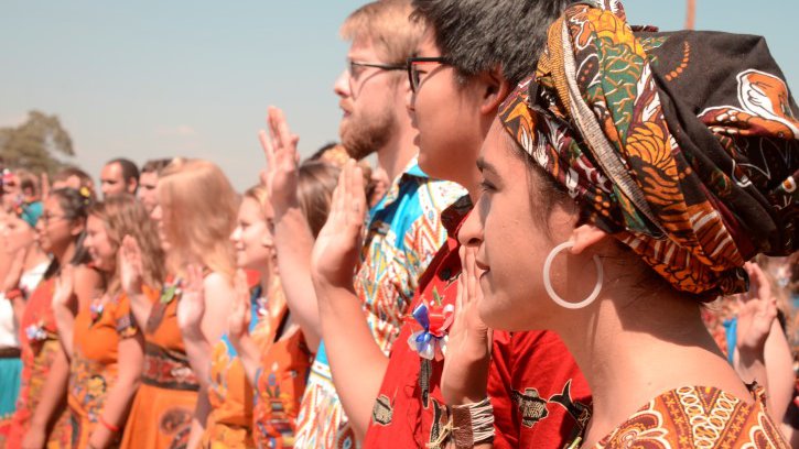 Trainees stand in a village in Malawi, waiting to be Sworn-In as Volunteers