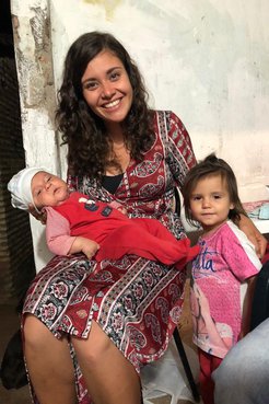 A PCV in Paraguay poses with the babies of her host family.