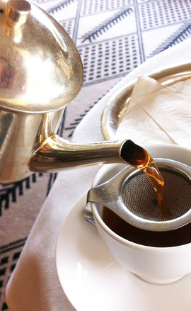Tea being poured through a strainer