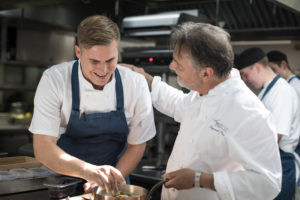 raymond-blanc-in-kitchen-with-chefs-300x200.jpg