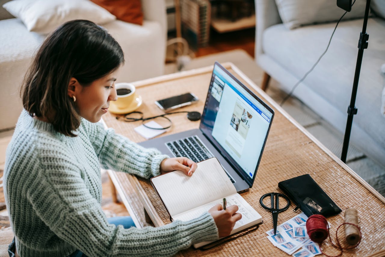 woman sitting at laptop taking notes
