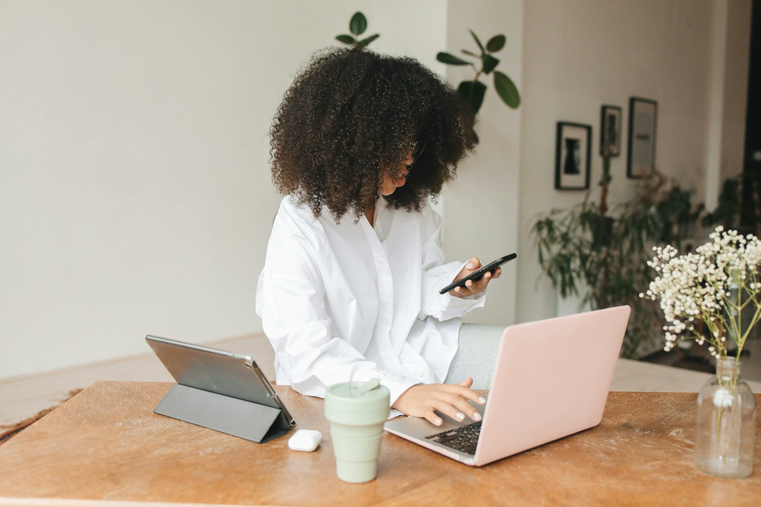 Professional woman learning on laptop, tablet, and smartphone at once, representing flexible microlearning for associations.