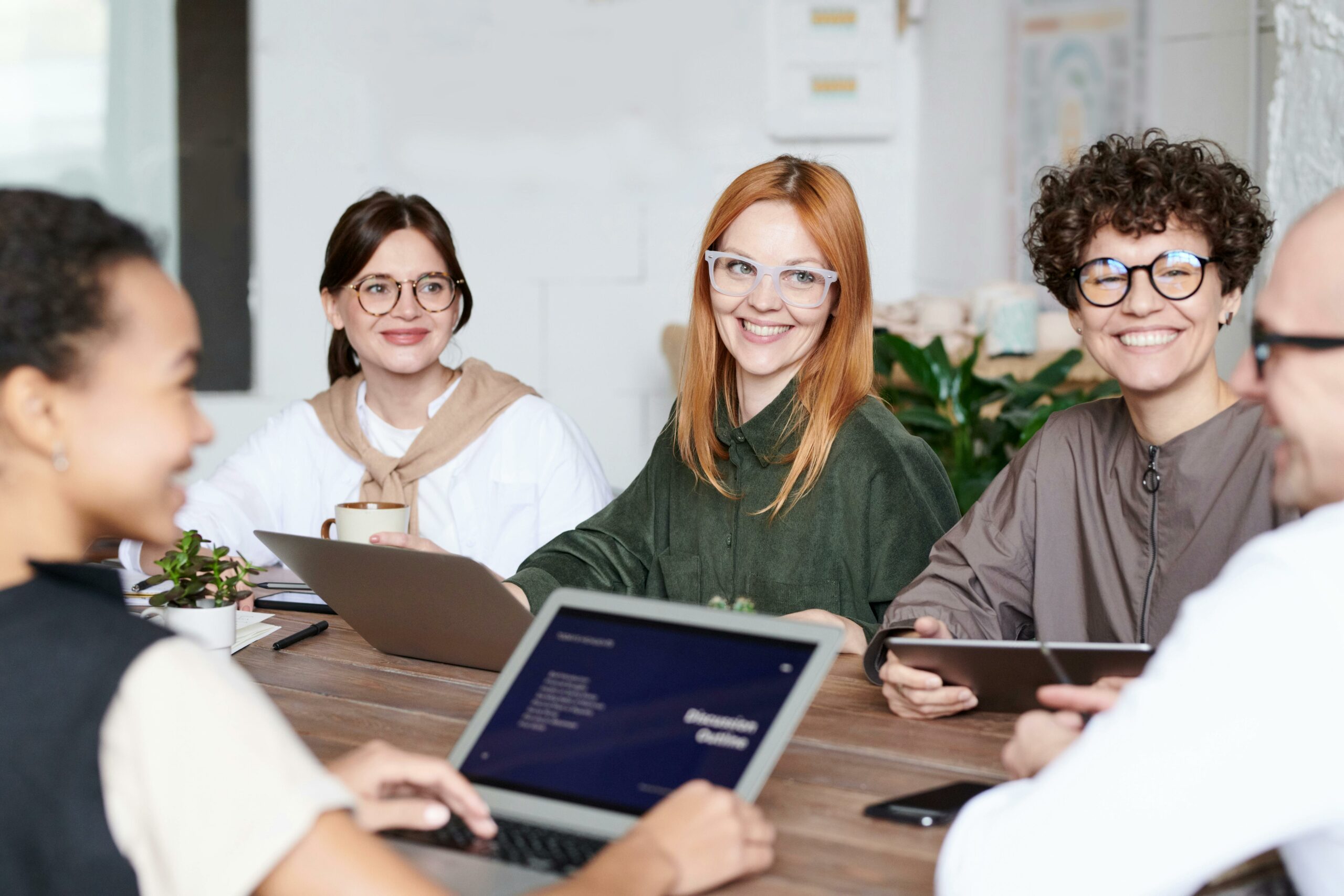 Group of professionals collaborating in a meeting with laptops and tablets, representing pharmaceutical and healthcare association engagement strategies.
