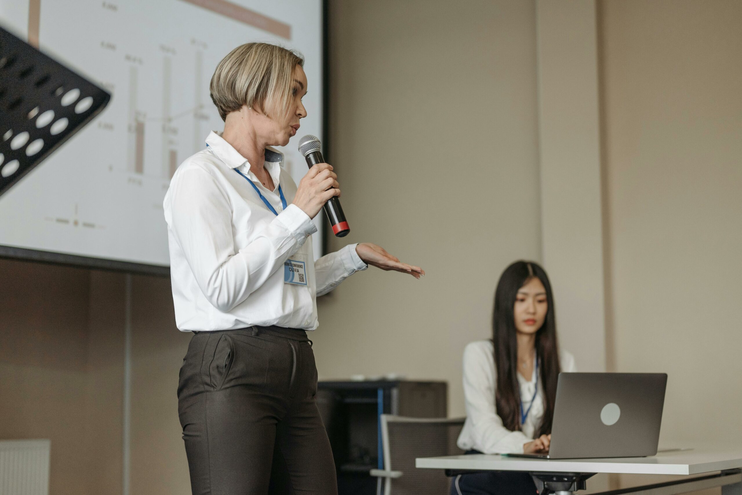 Woman giving a keynote presentation at a live event, being recorded for future association content
