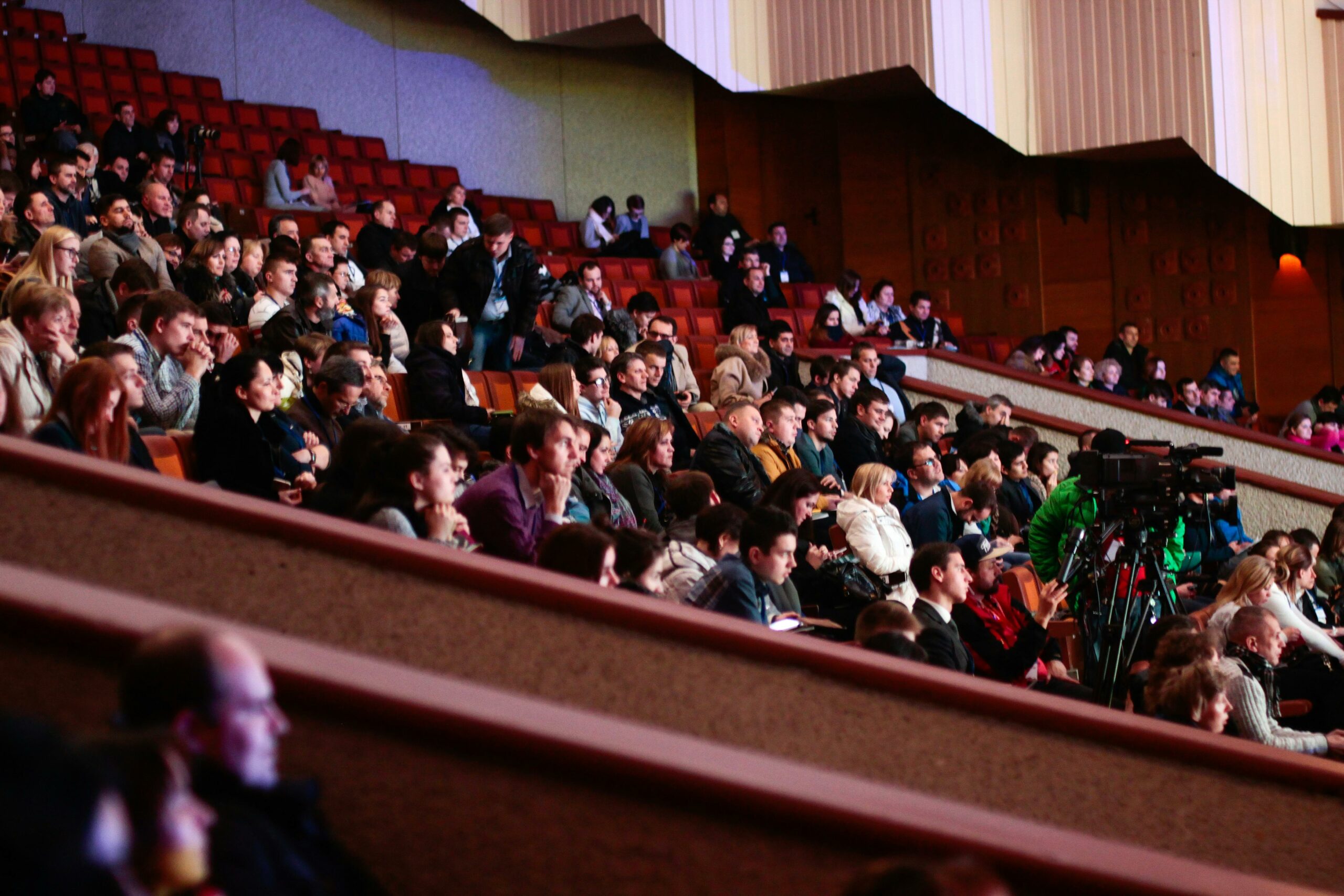 audience in conference venue with video production that captures the event highlights and moments for post-event marketing use