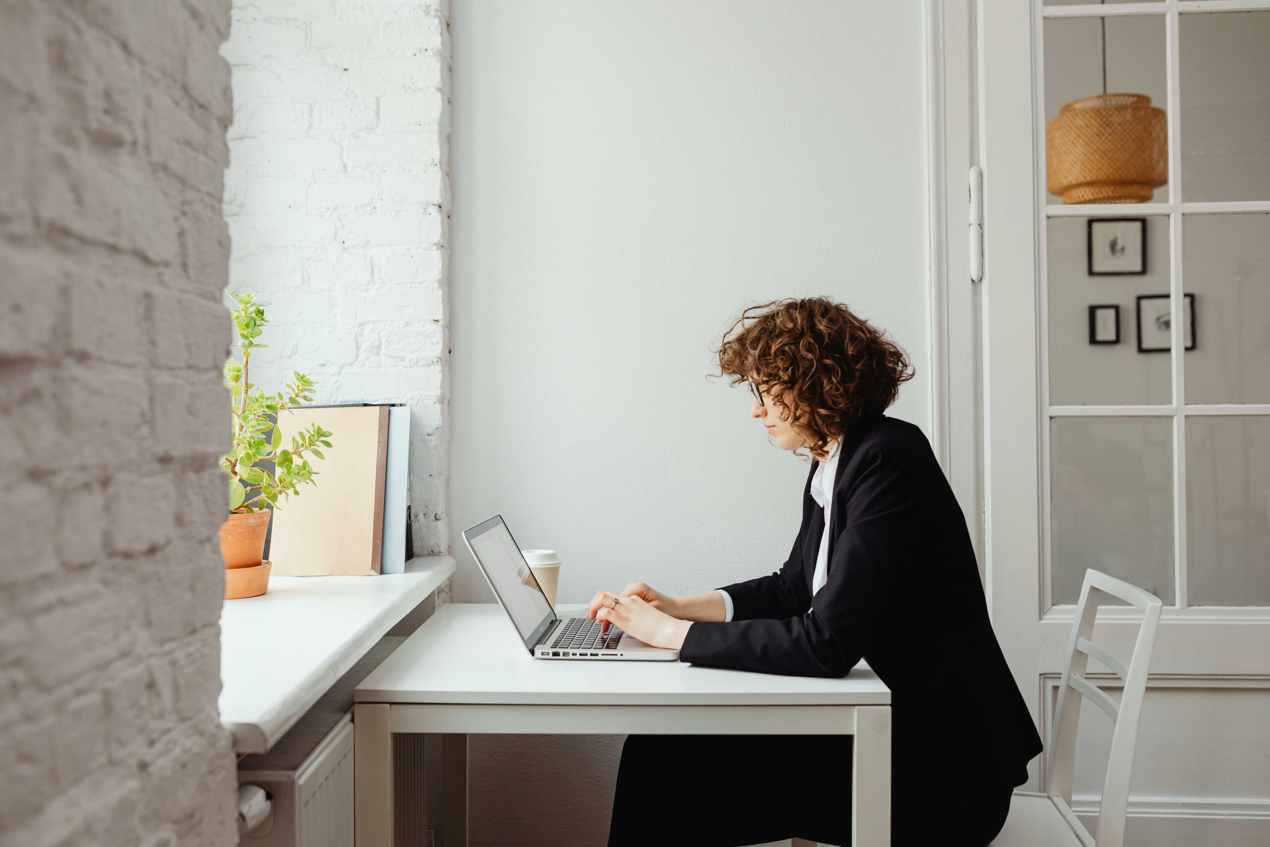 A person working on a laptop in a bright, modern workspace, viewing digital content on a media platform.