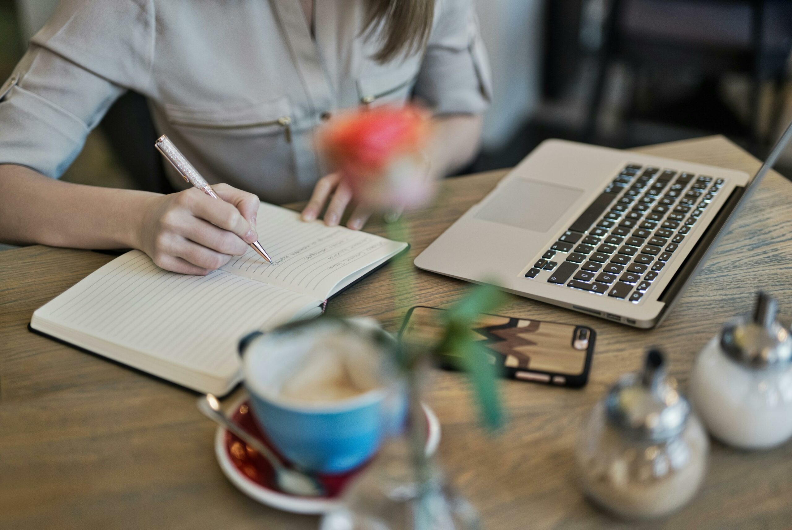 A woman is and writing, strategizing and organizing the pillar content with topic clusters.