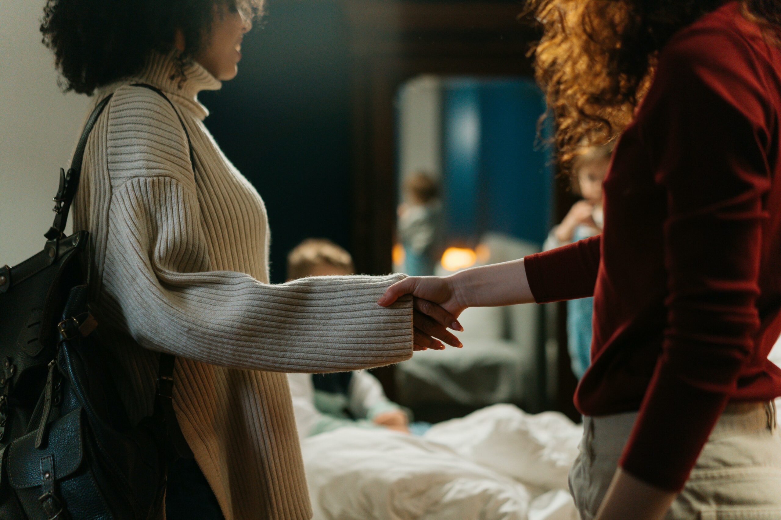 Two professional women shake hands and forge partnership for an association journal advertising