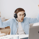 an association member is in front of his laptop and has his hands up in air in amazement of the online e-learning experience from the association
