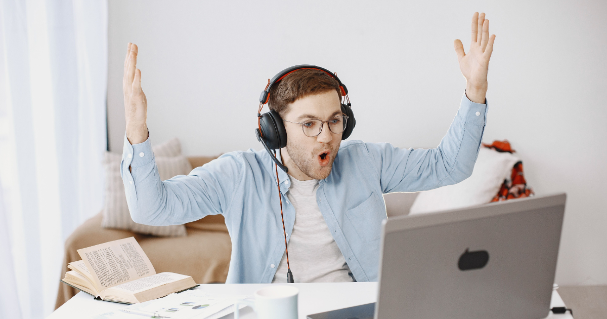 an association member is in front of his laptop and has his hands up in air in amazement of the online e-learning experience from the association