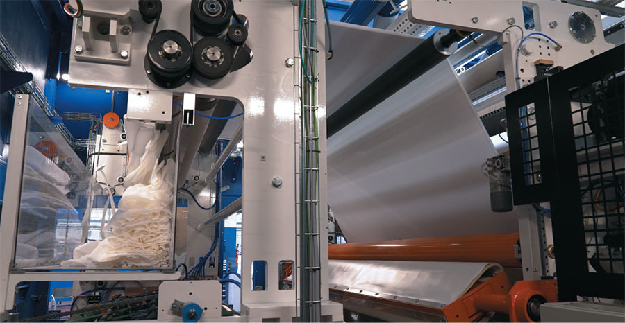 a belt carries excess cut paper to a waste bin above the tail sealer