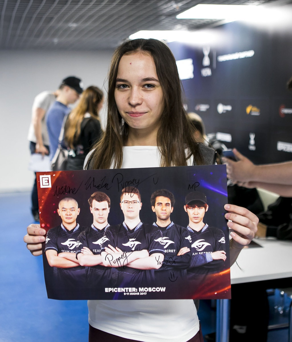 Un aficionado recibe un póster de Team Secret firmado en el Epicenter 2017: Moscow Dota 2 competition.