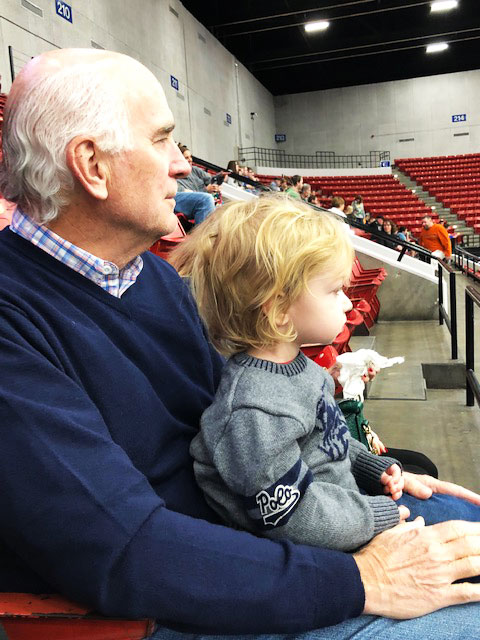 Una foto reciente de Carrier sosteniendo a su nieto Beckett en un juego de fútbol bajo techo.