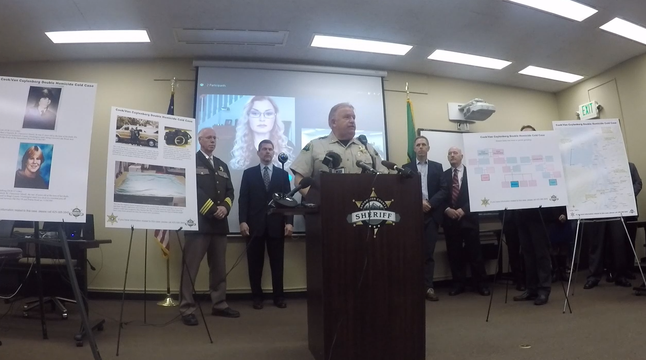 Genealogist CeCe Moore aparece en una pantalla detrás del sheriff del condado de Snohomish Ty Trenary en mayo. Moore ayudó a la policía a identificar a un sospechoso de asesinato, William Earl Talbott.