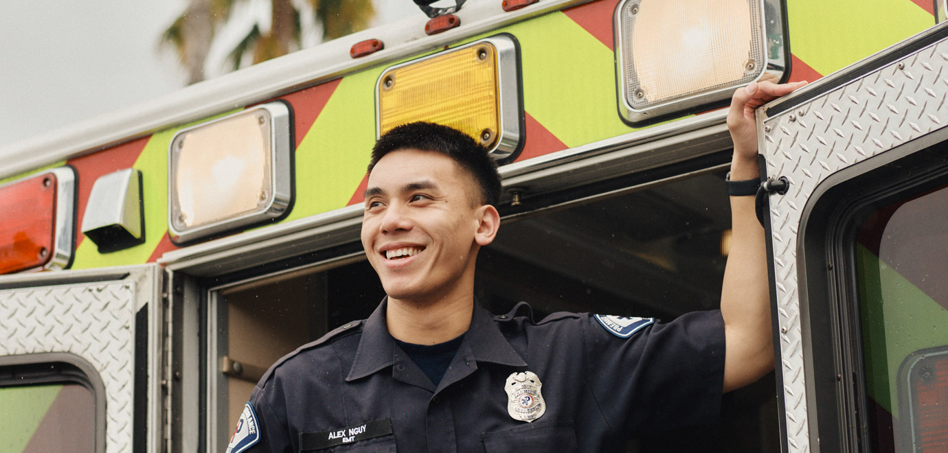 Alex stands on the back door of an ambulance