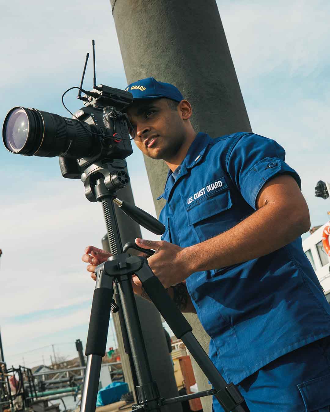 Petty Officer Third Class in the coast guard, Anthony Pappaly sets up his camera for a shoot